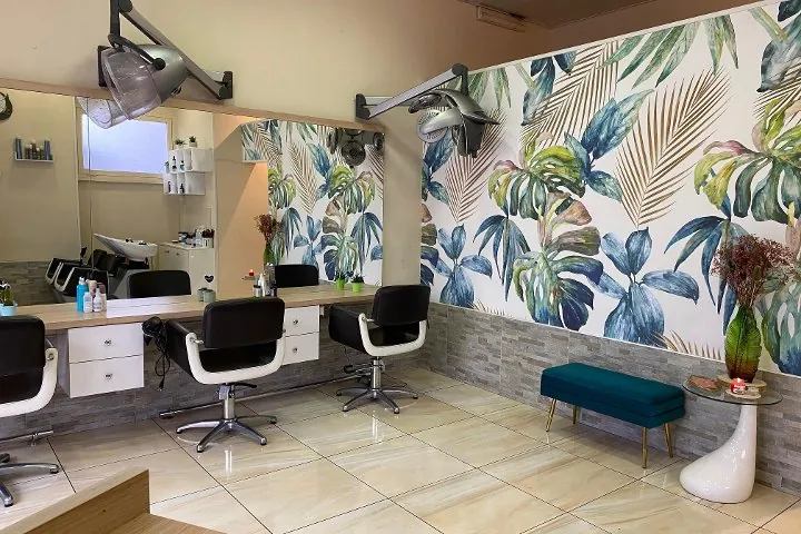 La sala con le postazioni bianche e nere, i caschi a parete e la carta da parati tropicale